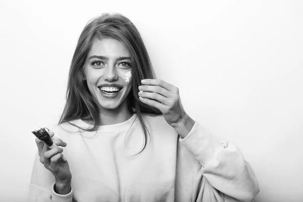 Glückliches hübsches Mädchen, das Gesichtscreme oder Maske aufsetzt — Stockfoto