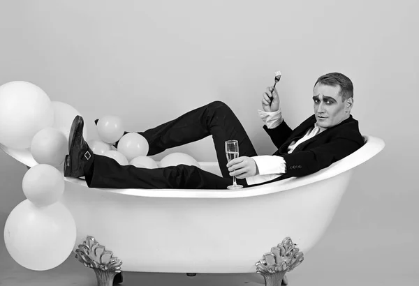 Estou a comemorar. O ator mímico gosta de tomar banho na banheira. Banho e relaxamento. Homem mímico tem festa de celebração com comida e bebida. O ator comediante celebra férias. Feliz dia de banho de bolhas — Fotografia de Stock