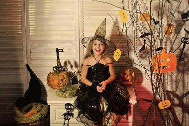 Cadı şapka ve kostüm oturur korkunç dalları yakınındaki evlat