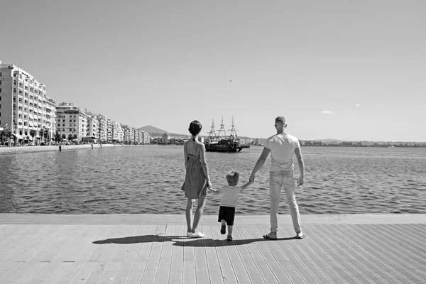 El amor y la confianza como valores familiares. Madre y padre con hijo miran a raya con la nave. Niño con padre y madre. Vacaciones de verano de familia feliz. Viajes en familia con niños el día de la madre o el padre . — Foto de Stock