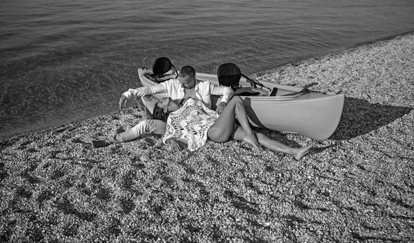 Summer holidays and marine trip. Love relations of couple enjoying summer day together. Sexy woman and man at sea water near boat. Family and valentines day. Couple in love relax on beach sand