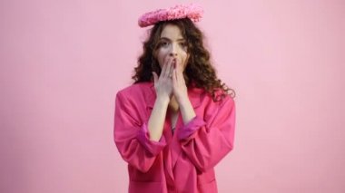 Pembe bir arka plan üzerinde elinde kalp ile kız pembe ceket. Aşk kavramı. Güzel baştan çıkarıcı genç kadın. Sevgililer günü hediyesi. Pembe arka plan.