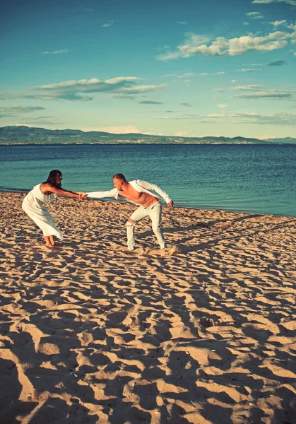 Pareja alegre corriendo en una playa de arena —  Fotos de Stock