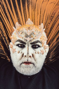 Dikenler veya siğiller, baş yüz pırıltılar ile kaplı, yakın çekim. Uzaylı, iblis büyücü makyaj. Sakallı canavar makyaj ile komuta sizde. Fantezi kavramı. Altın yaka, siyah arka plan ile iblis.