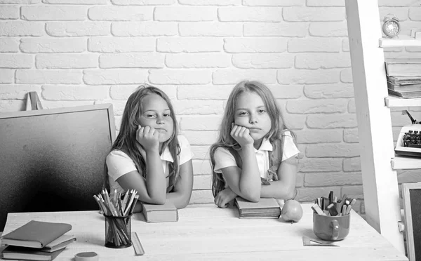 De schooltijd van meisjes. Terug naar school en huis het scholen. Kleine meisjes eet appel bij de lunchpauze. Vriendschap van kleine zusters in de klas op de dag van de kennis. verveeld schoolkinderen op les in september 1 — Stockfoto