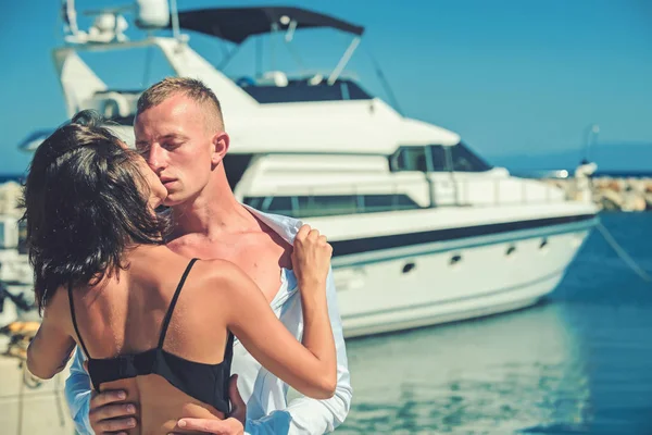 Liebespaar küsst sich am Strand in der Nähe von Luxusjacht. — Stockfoto