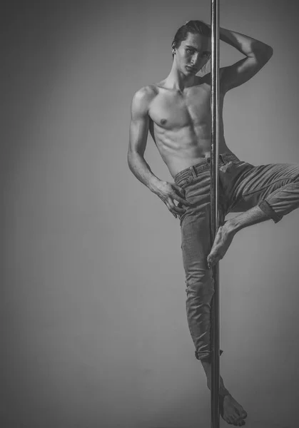 Sport and art concept. Athlete, sportsman performing pole dancing moves,