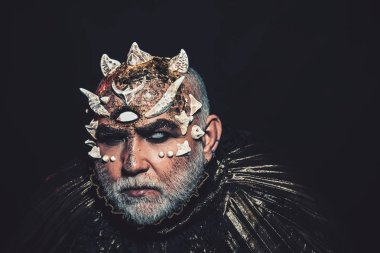 Uzaylı, iblis büyücü makyaj. Üçüncü göz, dikenler veya siğiller olan adam. Siyah arka plan, kopya alanı cehennemdeki şeytanlar. Beyaz sakallı komuta sizde karanlıkta canavar gibi giyinmiş. Korku ve hayal kavramı