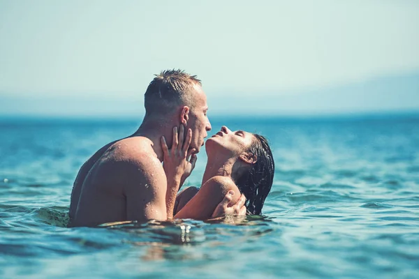 Reisen und Urlaub. Reise von sexy Paar küsst sich im Ozeanwasser. — Stockfoto