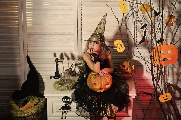 Pequeña bruja con decoración de Halloween. Chica con cara sospechosa —  Fotos de Stock