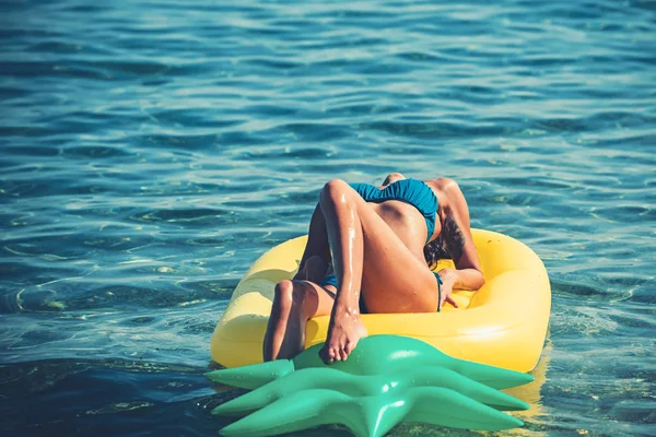 Matelas gonflable ananas, activité et joie. Fille bronzer sur la plage avec matelas gonflable. Maldives ou Miami plage d'eau. Femme sexy sur la mer des Caraïbes aux Bahamas. Vacances d'été et voyage à l'océan — Photo