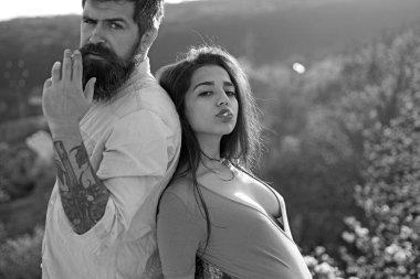 Açık havada, Sigara rahat yüzündeki defocused arka plan, doğa birkaç. Sigara alışkanlığı kavramı. Erkek ve kadın bahar gününde sigara tutar. Aşık çift harcamak zaman açık havada ve yasaktır.