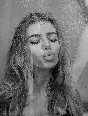 Spa ve güzellik. kaplıca tedavisi pencere cam su damlaları ile tutarak uzun kıvırcık saçlı Genç kadın.