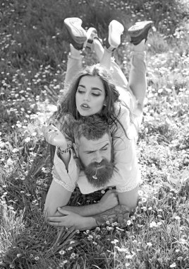 Aşık çift harcamak zaman açık havada ve yasaktır. Gülümseyen yüzler doğa üzerinde arka plan açık havada, Sigara çift. Erkek ve kadın üzerinde çim döşeme bahar günü. Sigara alışkanlığı kavramı.