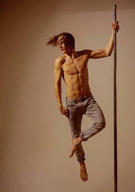 Erkek kutup dans atlet gri Studio pilon üzerinde.