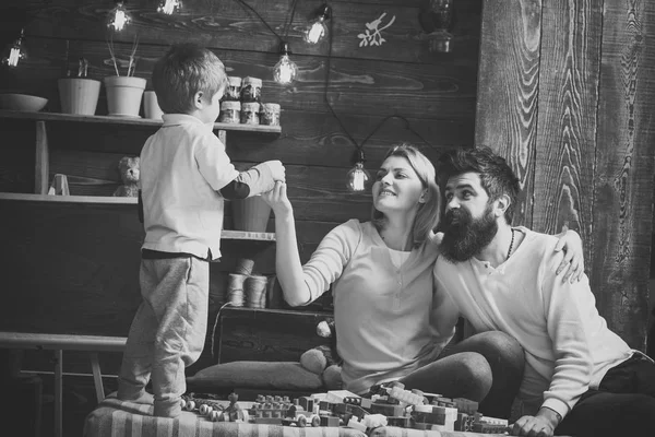 Happy family playing with constructor at home. mother and father looking with emotion at their cute toddler son. — Stock Photo, Image