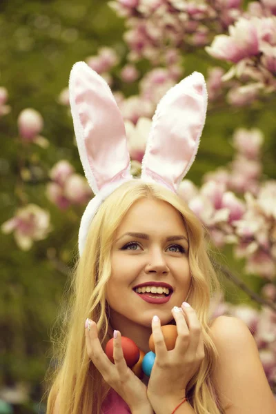 Huevos de Pascua en tenía de chica feliz en orejas de conejo —  Fotos de Stock