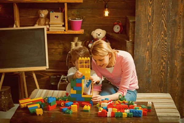 Побудова концепції. Мати і син граються з будівельними блоками. Мати і дитина будують структуру з іграшкової цегли. Побудова соціальних навичок та побудова довіри — стокове фото