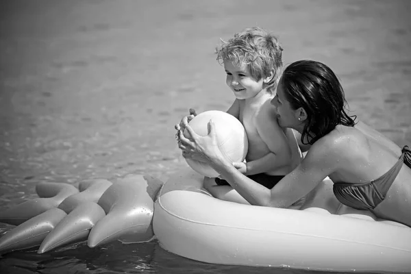 Vacaciones de verano y viajes al océano. Familia feliz en el mar Caribe. Maldivas o Miami playa actividad alegría. madre con hijo jugar pelota en el agua en el día de las madres. Colchón inflable de piña, vintage . —  Fotos de Stock