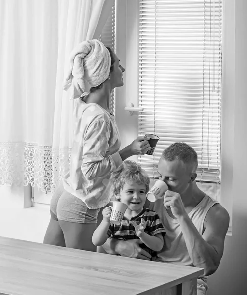 Pessoas, conceito de família e manhã - criança feliz com os pais bebem leite em casa — Fotografia de Stock