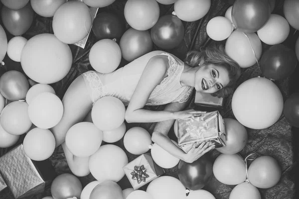 retro woman in balloons with birthday gift.
