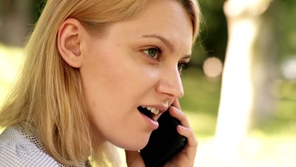 Escritório ambiente natural. Trabalho ao ar livre benefícios. Tecnologia da educação e conceito de internet. Trabalho de sonho online. Close-up de uma menina que fala por telefone no parque. Fundo verão parque verde . — Vídeo de Stock