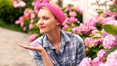 Kadın bakım onu bahçesinde bahar çiçeklenir. Kadın için pembe ortancaları umurunda değil. Çiçekler için bakım kavramı. Pembe ortanca. Pembe çiçekler. Dikilen kadın bahar çiçekleri.