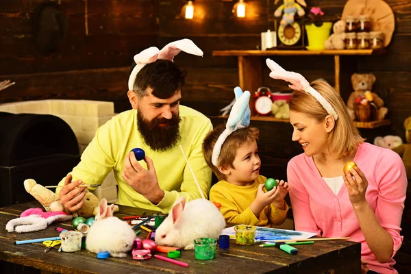Baba, anne ve çocuğunu Paskalya yumurta boyama keyfini çıkarın. — Stok fotoğraf