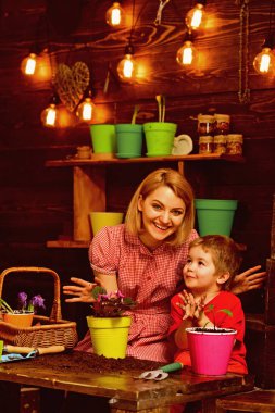 Dünya gün kavramı. Anne ve küçük oğlu Çömlekçilik toprak gününde çiçek. Anne ve çocuk çiçek yeni tencerede dünya günü değiştirmeliyiz. Mutlu dünya günü