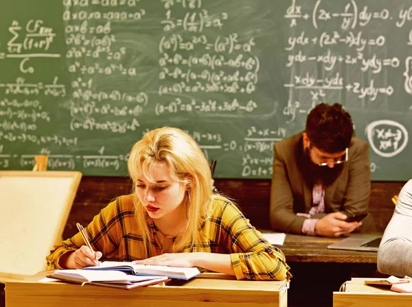 Студенти працюють чесно. Студент здає екзамен евфоричній дівчині, яка дивиться ноутбук у класі. Вплив вчителів слідує за студентом протягом усього життя . — стокове фото