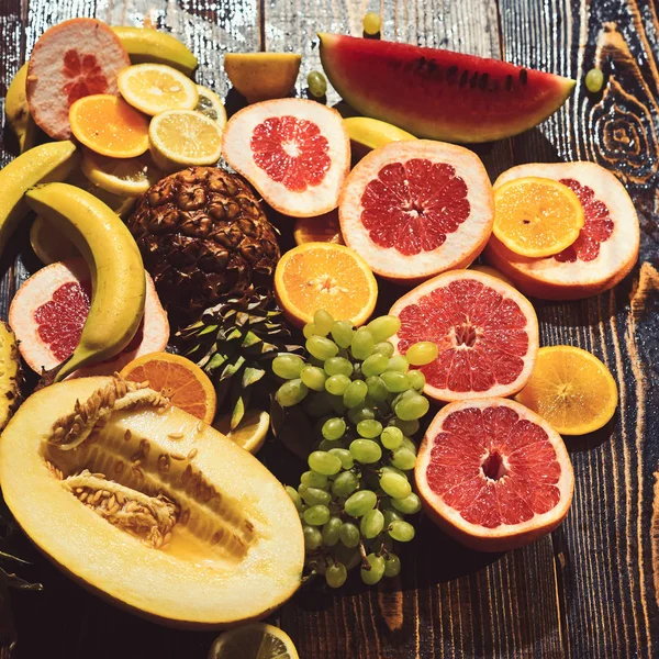 Vitamín potravin a zdraví jíst meloun a meloun s banánem. oranžové ananas citron s rozložením grapefruitu a hrozny. Čerstvé ovoce na dřevěný stůl. Exotické a tropické ovoce. Detoxikační dieta koncept — Stock fotografie