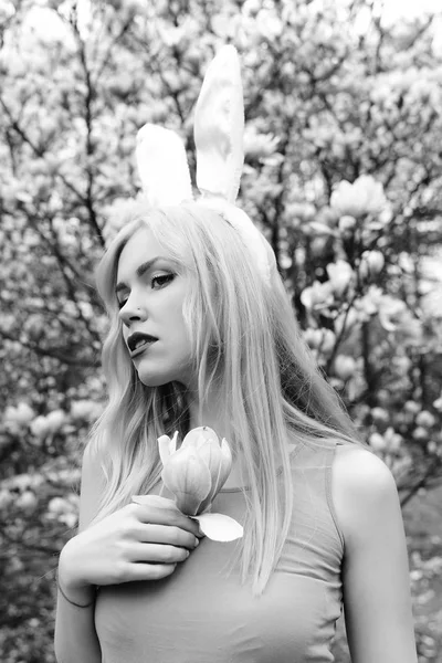 Mladá žena s uši zajíček s květů magnólie — Stock fotografie