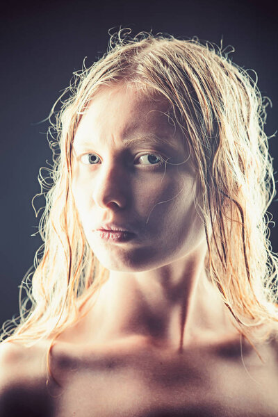 Портрет молодой альбиносы с открытыми глазами на тёмном фоне
