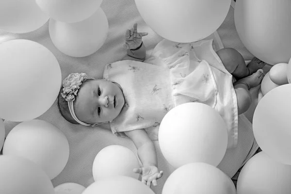 La maternidad es pura alegría. Felicidad infantil. Niña pequeña. Feliz cumpleaños. Dulce bebé. Nueva vida y nacimiento. Familia. Cuidado de niños. Día de los niños. Retrato de niño feliz en globos blancos — Foto de Stock