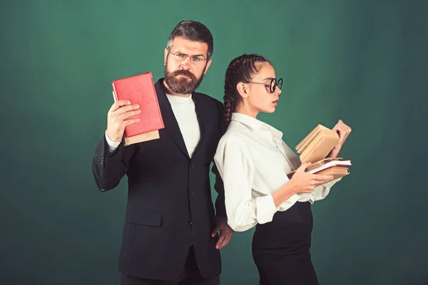 Bildung im Wissenstag. Literaturstunde und Grammatikbuch lesen. Schulzeit von Tochter und Vater in der Bibliothek. Lehrer und Schüler halten Bücherstapel in der Schule. zurück zur Schule und zum Schulbesuch zu Hause — Stockfoto