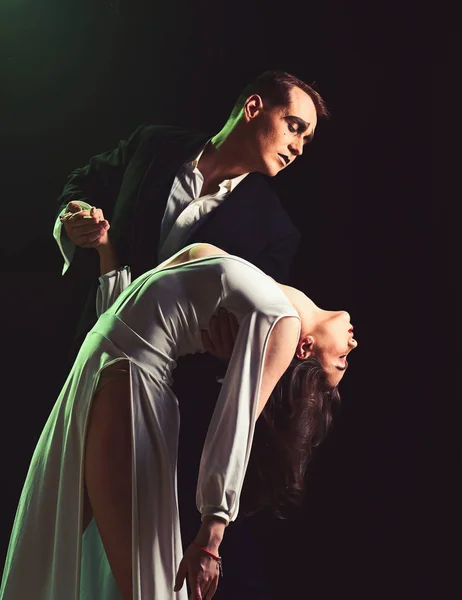 True love at its finest. Couple of mime artists perform romance on stage. Mime man and woman act in romantic scene. Couple in love with mime makeup. Theatre actors miming through body motions