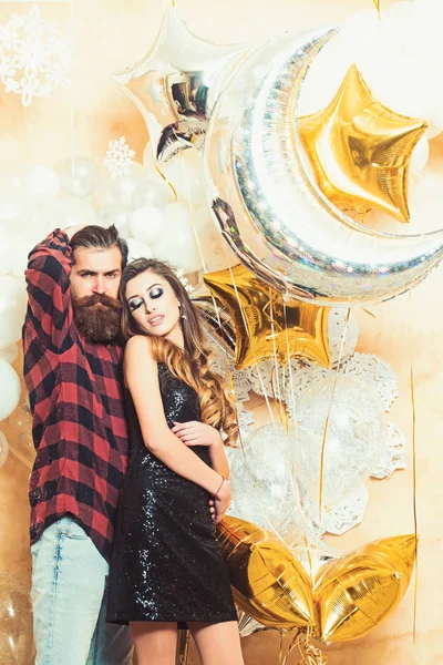 Coppia innamorata godere festa festa festa. Hipster e donna a Capodanno o la vigilia di Natale. Donna sensuale e uomo barbuto con palloncini da festa, Natale. La famiglia felice festeggia il Natale e l'anno nuovo — Foto Stock