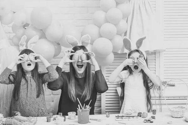 A mother and her daughters are painting eggs. — Stock Photo, Image