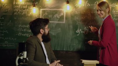 Kız öğrenci yanıtları öğretmen kurulu yakınındaki önce hayran. Sınıf arkadaşım bilgi ders kavramı eğitmek. Öğretmen sınıfta masada oturuyor. Eğitim, okul, kolej ve üniversite kavramı.