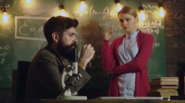 Öğrenci ve öğretmen önünde üzerinde formüller yazılmıştır yönetim kurulu iletişim. Öğrenme kavramı. Öğretmen ve öğrenci. Okula dönüş. Eğitim, bilim, teknoloji, çocuk ve insan kavramı.