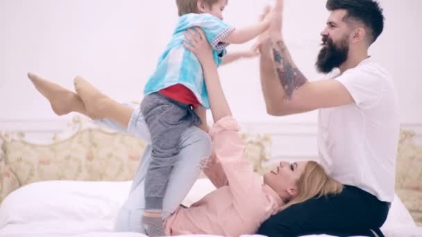 Famiglia si sta divertendo in camera da letto, sfondo interno di lusso. Concetto di amore, famiglia e felicità Concetto: bambini, bambini, bambini, bambini. Amare felice giovane madre abbraccia figlio e padre applaude in palma . — Video Stock