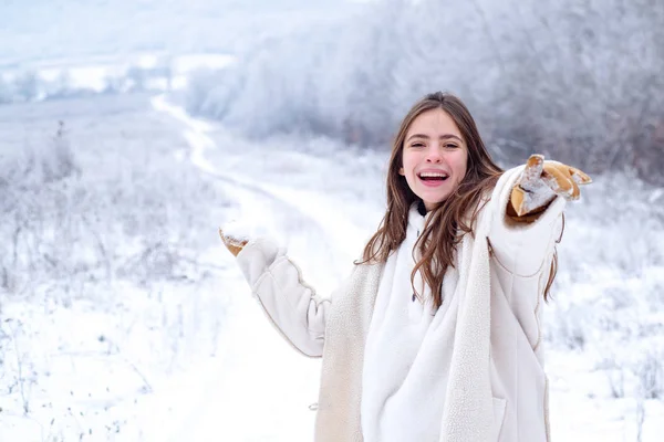 Γυναίκα ευτυχισμένη χειμώνα στο χιονισμένο φόντο. Εξωτερική όμορφη κοπέλα με μακριά μαλλιά, φορώντας πουλόβερ ποζάρει στον δρόμο της Ευρωπαϊκής πόλης. Χριστούγεννα, χειμώνας διακοπές έννοια. Χιονόπτωση. Χώρο αντίγραφο. — Φωτογραφία Αρχείου