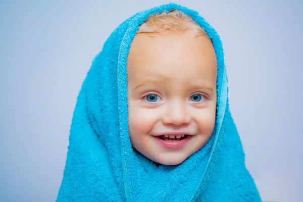 Sorrindo lindo bebê tomando banho sob um chuveiro em casa. Lavagem de bebê pequena com umas bolhas no banho em um chapéu. Feliz banho. Olhos azuis bebê . — Fotografia de Stock