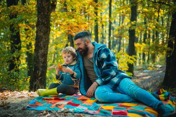 Dad with young son in autumn park. Father and son in sweaters in the park. Happy family, father and baby son playing and laughing on autumn walk. — Stock Photo, Image