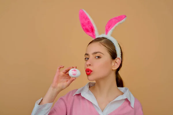 Usta i Wielkanoc, szminka pocałunek nadruk na easter egg. Wesołych Świąt. Młoda kobieta królik bunny uszy. Portret kobiety szczęśliwy w uszy królika. Polowanie na jajka. — Zdjęcie stockowe