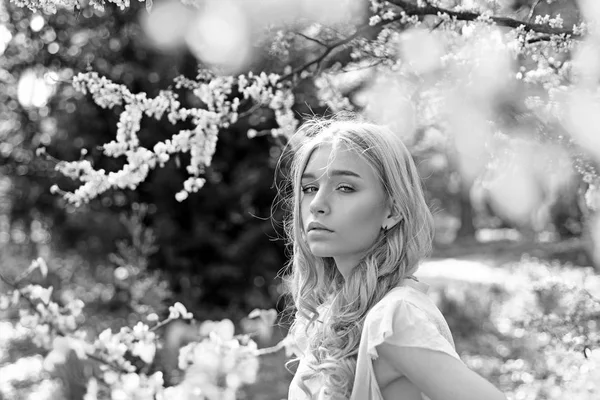 Lente bloei concept. Meisje op dromerige gezicht, tedere blonde in de buurt van violette bloemen van judas boom, natuur achtergrond. Lady wandelingen in het park op zonnige lentedag. Jonge vrouw genieten van bloemen in de tuin, intreepupil. — Stockfoto