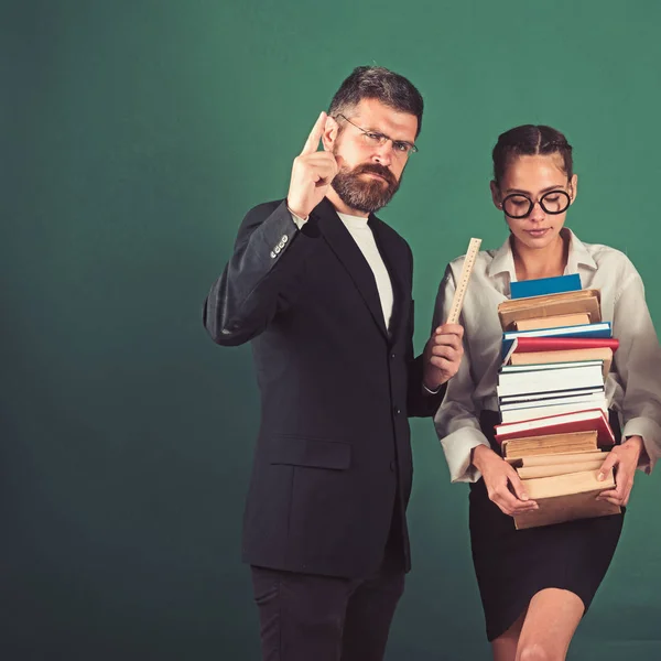 Bücherliebhaber. Bücherstapel in den Händen eines smarten Teenie-Schülers in der Schule mit bärtigem Lehrer, Kopierraum — Stockfoto