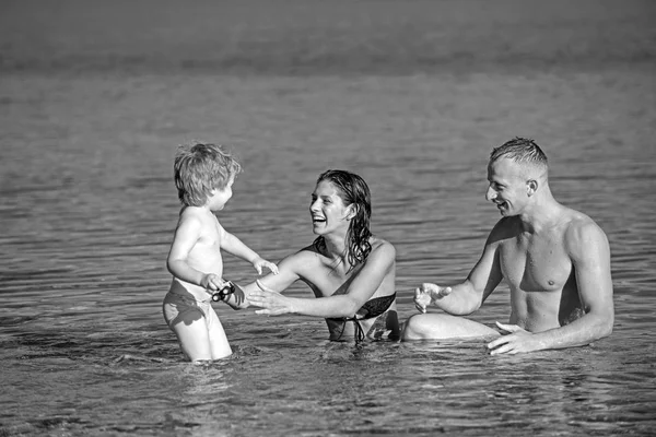 父と息子と母はビーチに海で泳ぐ。父と海や海の水で幸せな子供を持つ母. — ストック写真