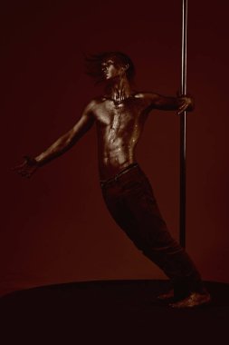 Güçlü dansçı egzersiz kutup. Özgürlük. Metal yüzey ile seksi maço. Pilon üzerinde dans gümüş gövde sanat kaslı adam. Pole dans spor. Atletik adam olun akrobatik öğeleri pilon üzerinde.