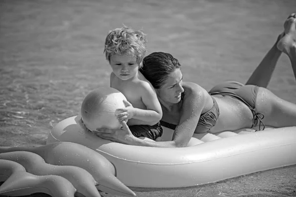 Feliz familia nadando en un colchón de aire, madre y chil juntos . — Foto de Stock